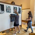 High school students setting up artwork for display.